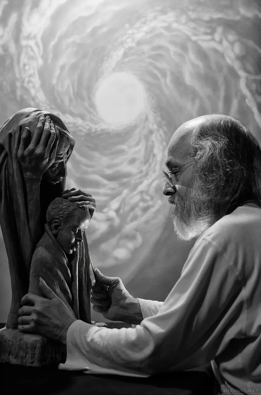 Two people posed beneath a swirling mural in black and white
