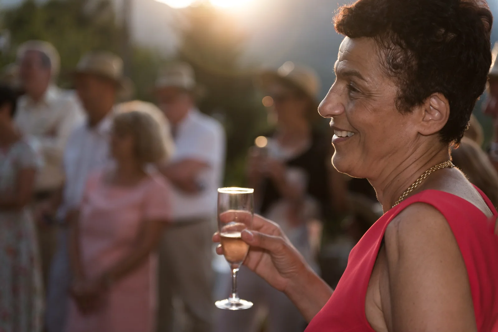 Guest holding a glass during a sunlit reception.