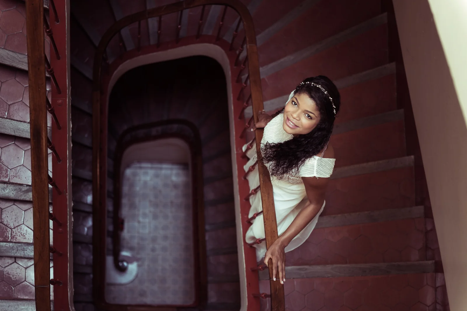 Bride leaning over a curved staircase.