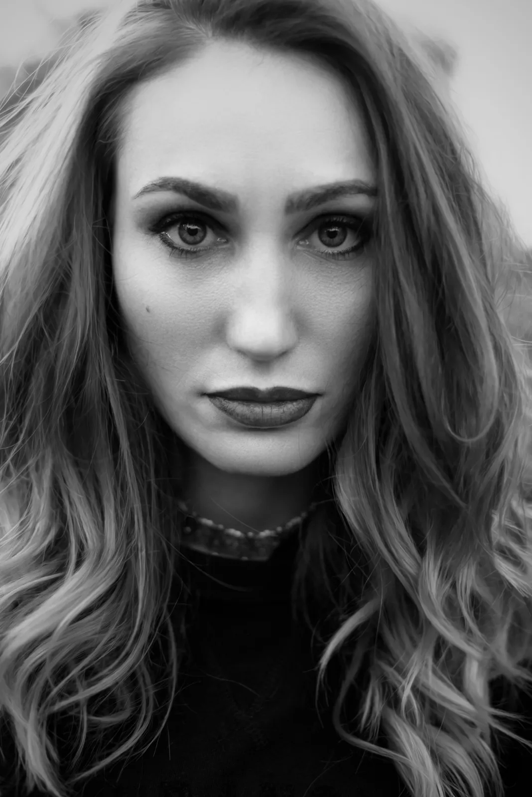 Black-and-white photograph: close-up portrait of a woman looking into the camera.