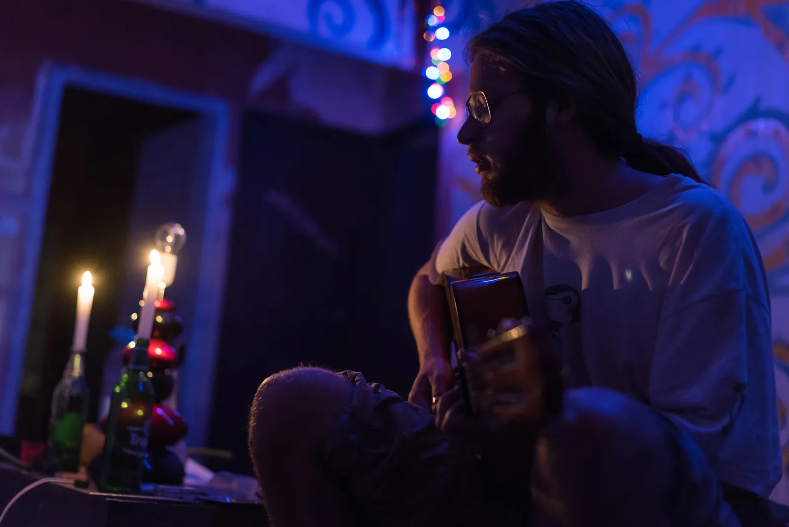 Musician performing under blue and purple lighting.