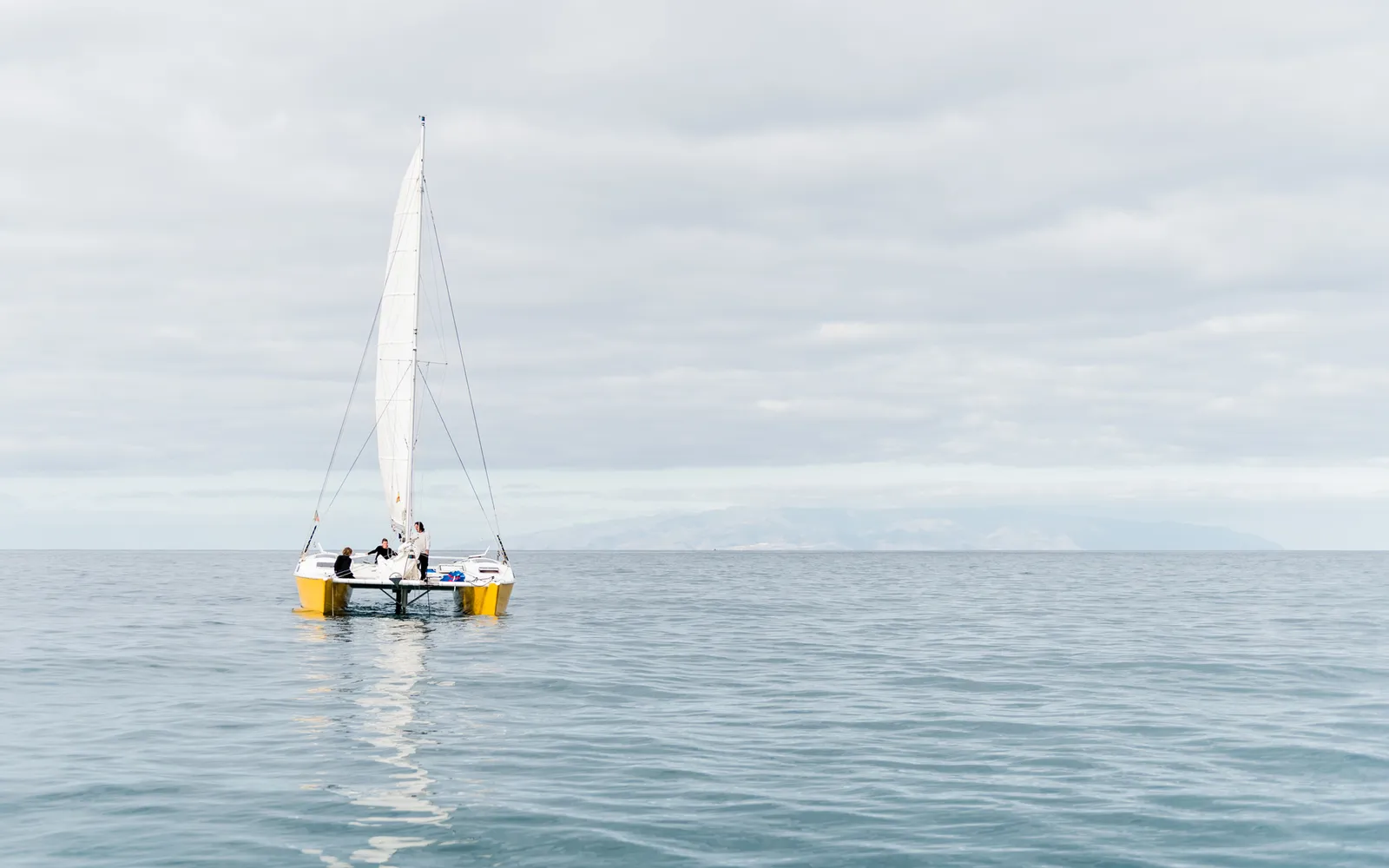Small sailboat on calm pale blue water
