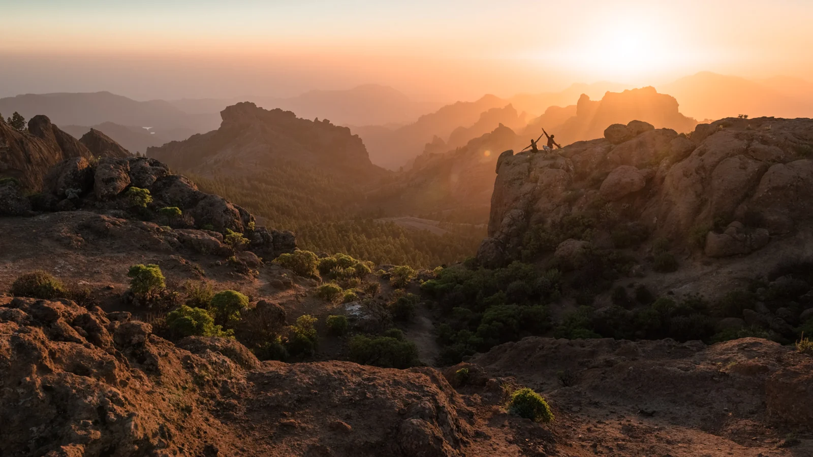 Sunset illuminating rugged mountain peaks and rocky foreground