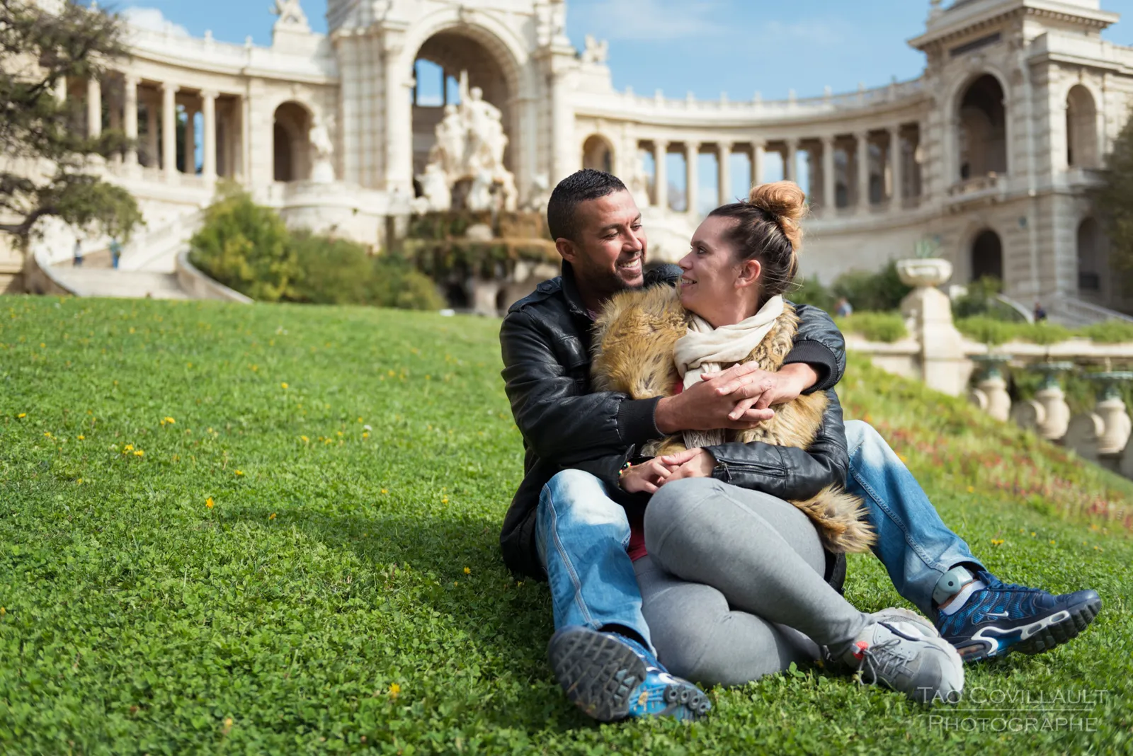 Couple relaxing together on grass.