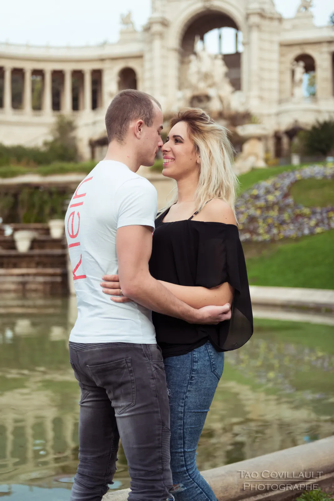 Couple standing together in front of an ornate building.