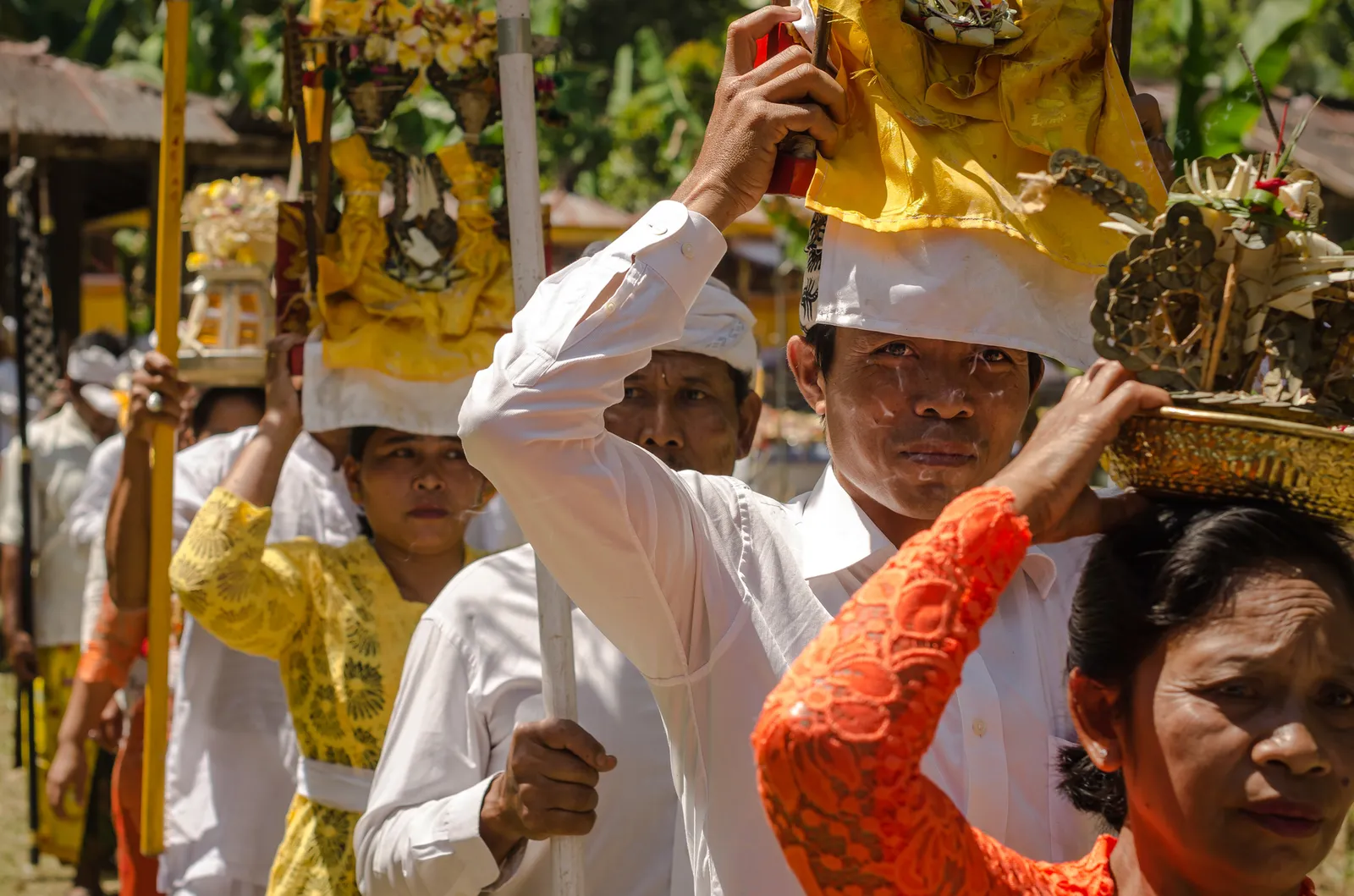 People carrying decorated offerings during a street procession