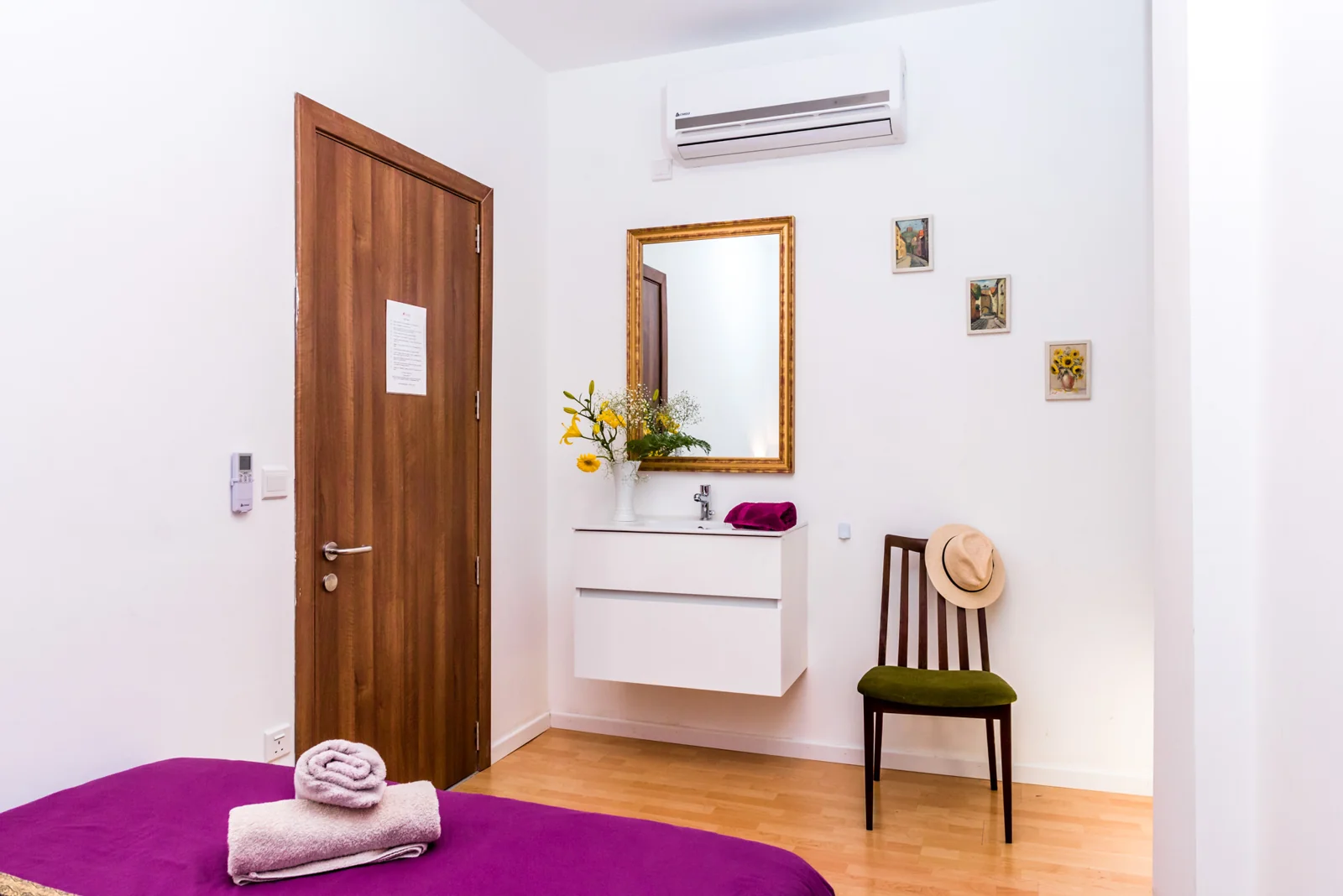 Bedroom entrance with a mirror and magenta bedding.