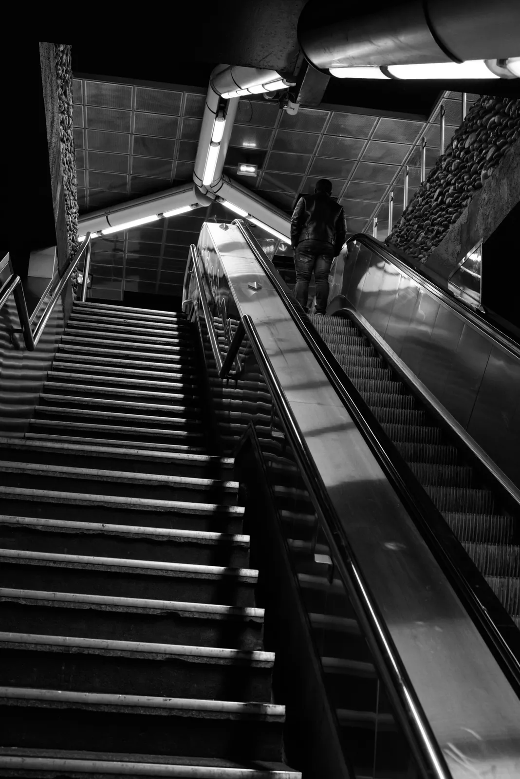 Steep station escalators in black and white