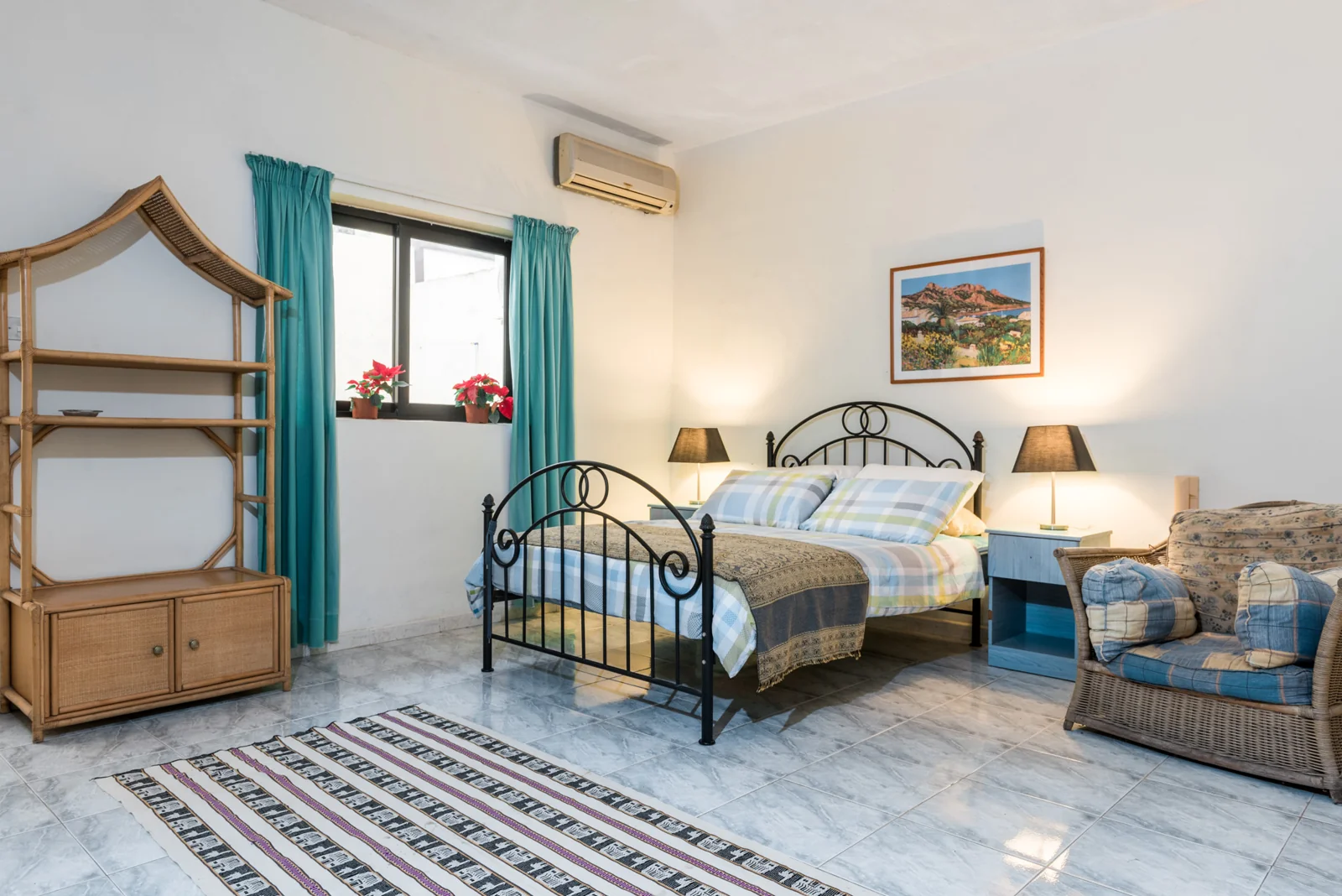 Bedroom with an iron bed and open green shutters.