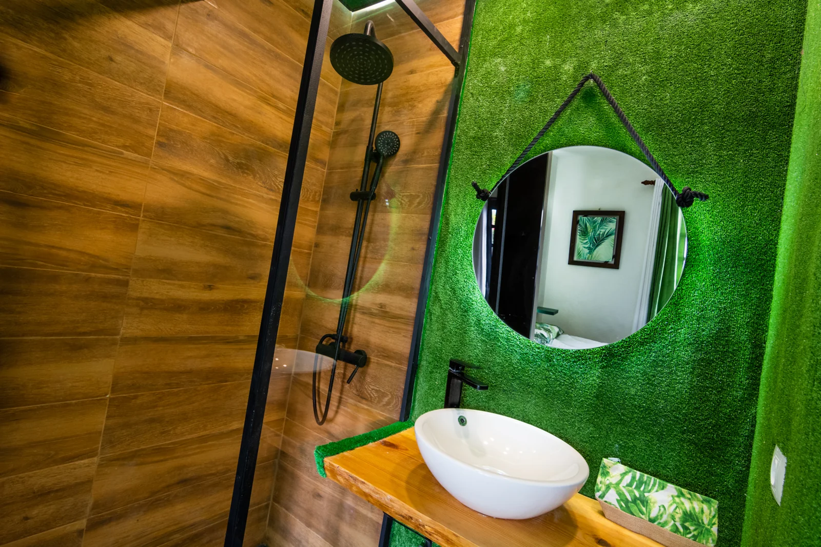 Bathroom with a round mirror and green wall.