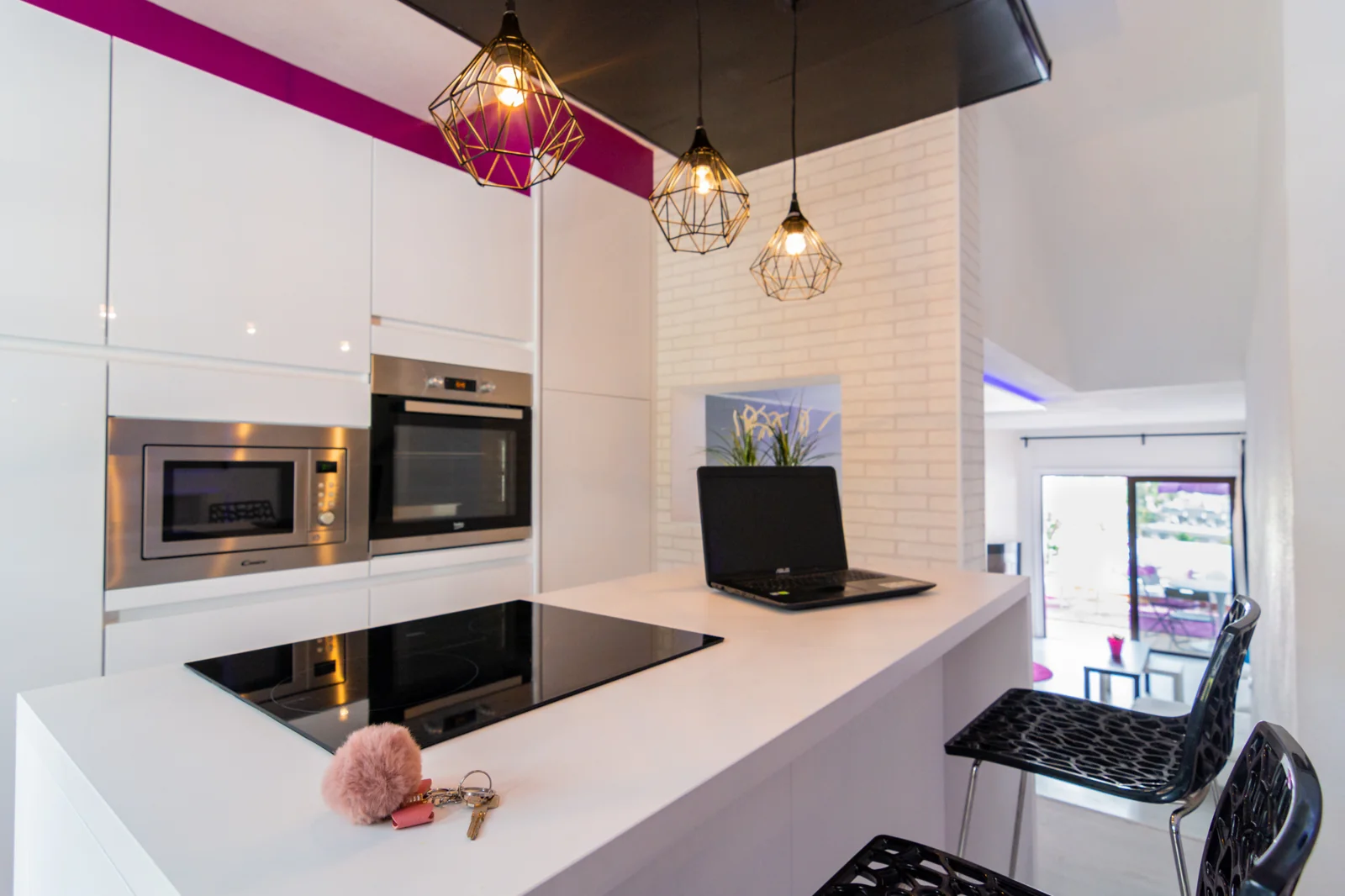 White kitchen island beneath warm pendant lights.