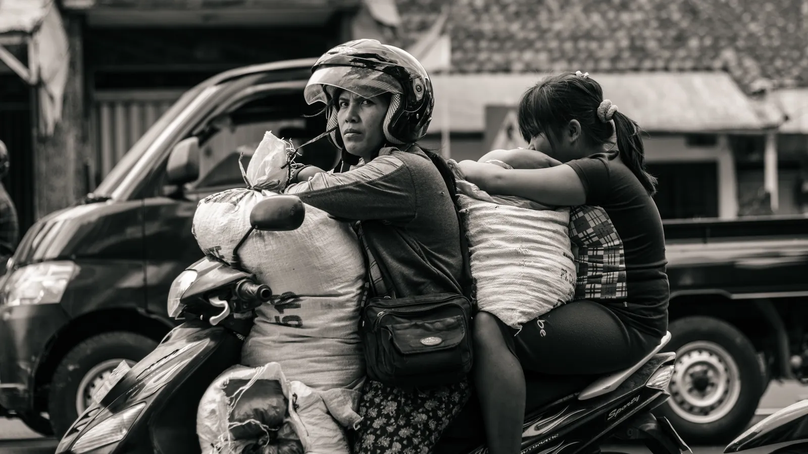 Scooter riders on a busy street in black and white