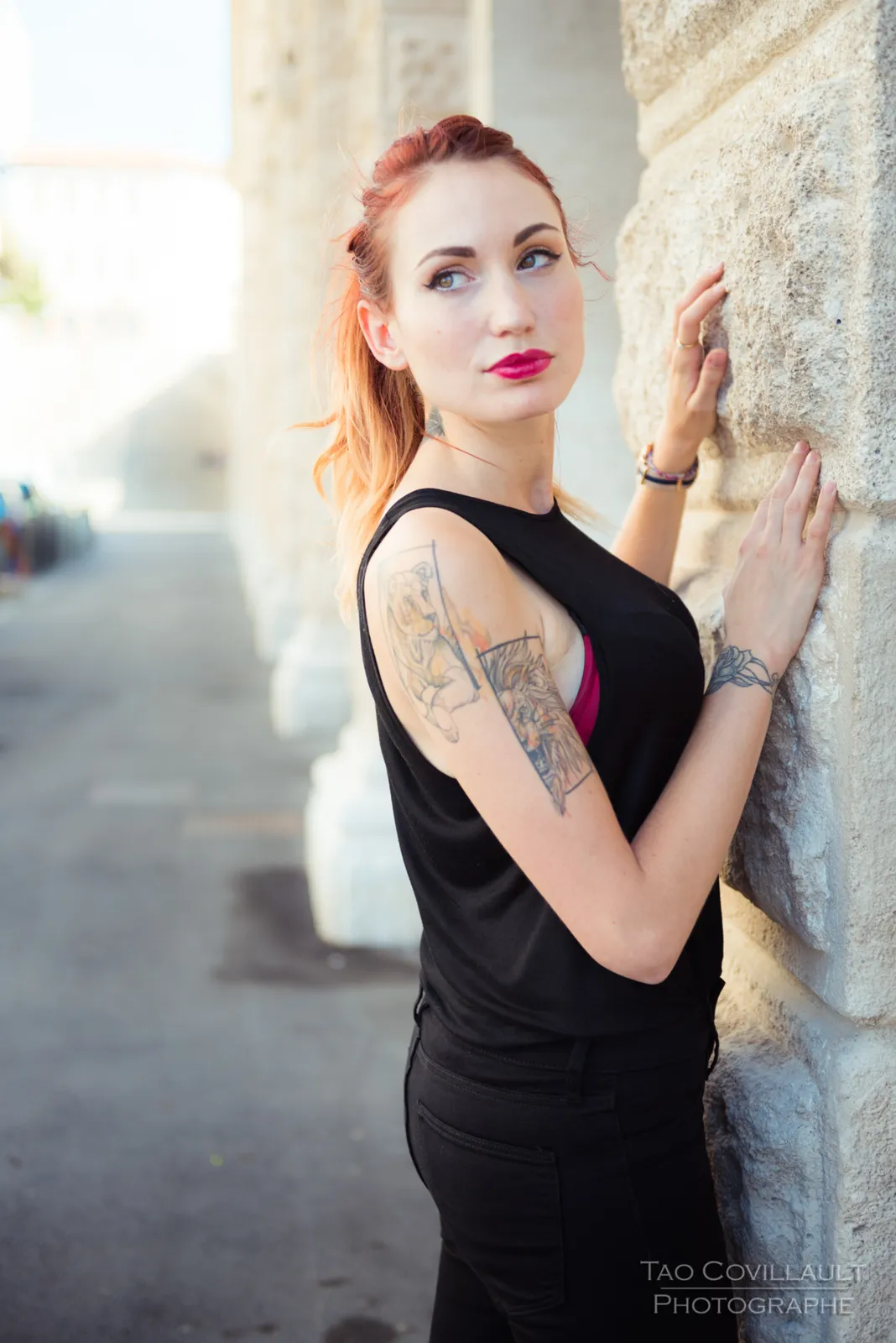 Woman in black clothing posing on pale stone steps.