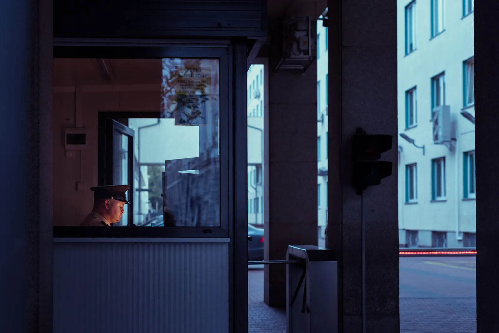 Small kiosk window opening onto a blue-lit street