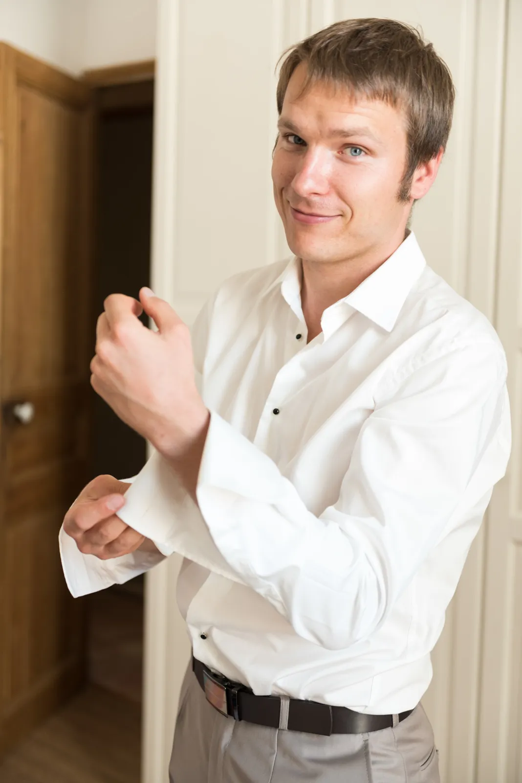 Groom adjusting his shirt before the ceremony.