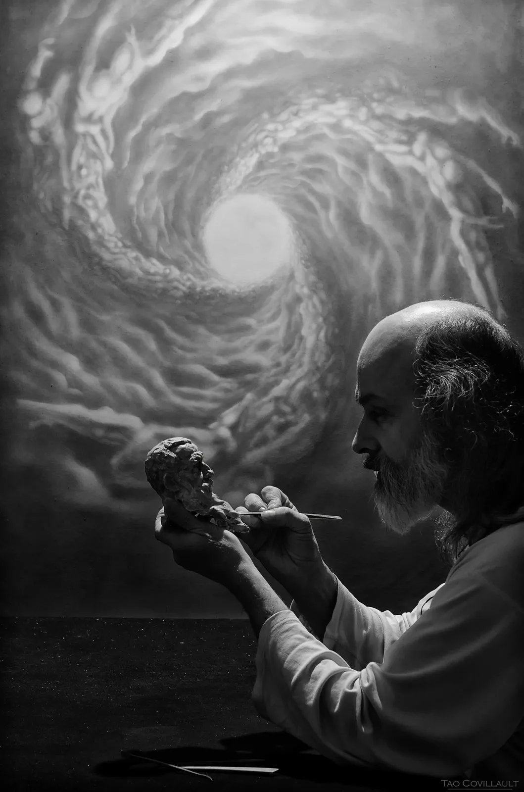 Black-and-white portrait beside a swirling painted mural