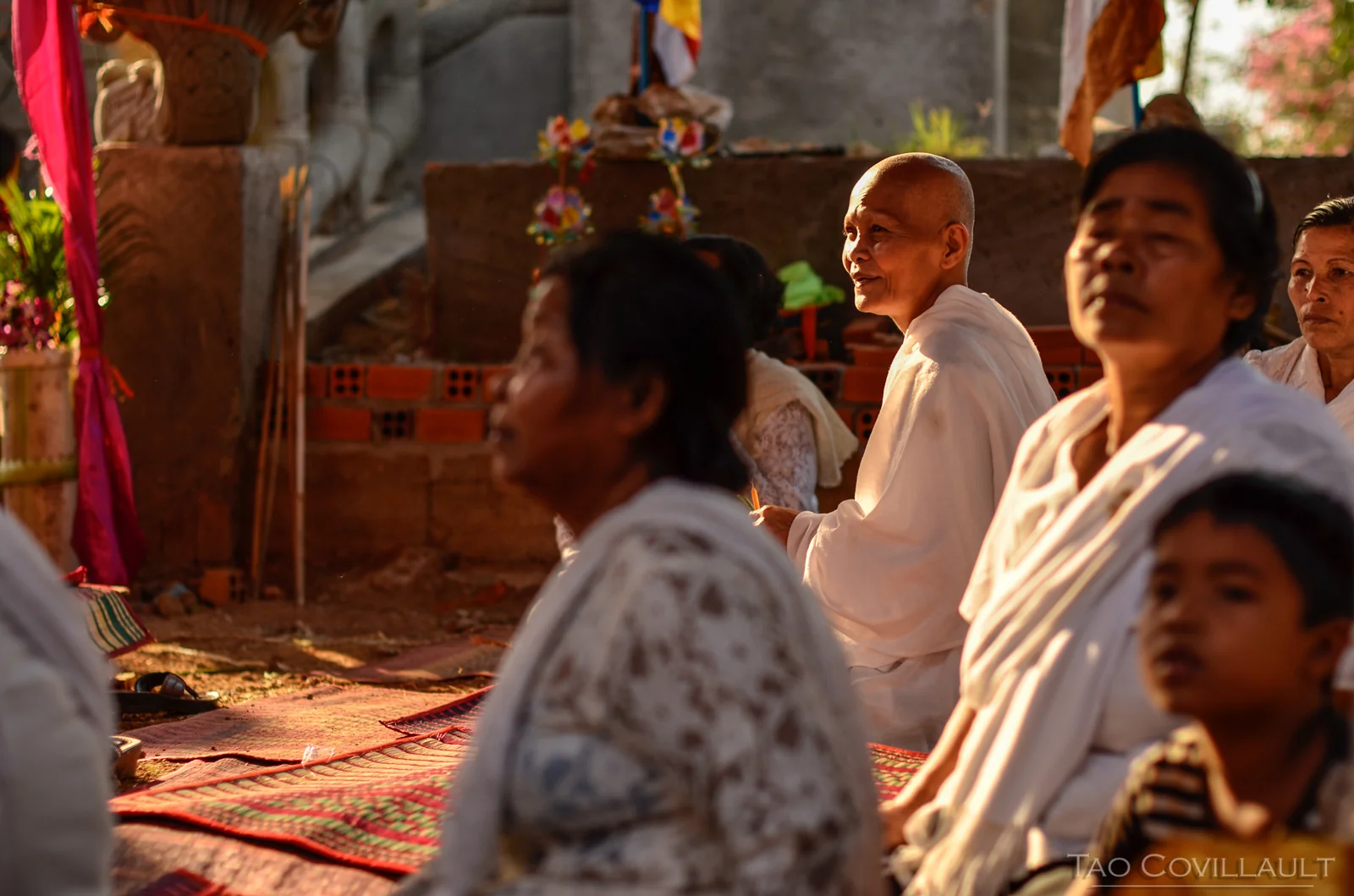 Adults and children gathered inside a temple.